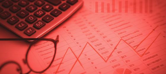 a cost chart, a calculator and a pair of glasses in the foreground