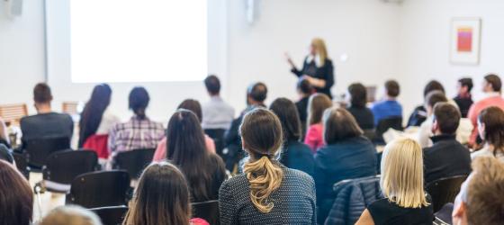 Female speaker giving a talk at classroom